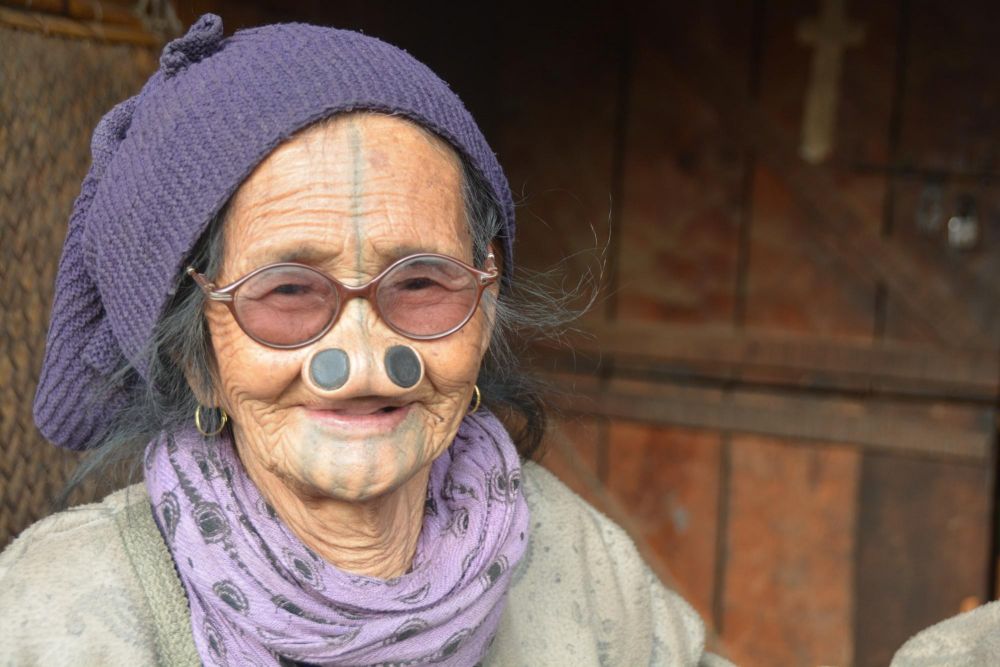 femme Apatani arborant les tatouages et bijou de bois dans les narines